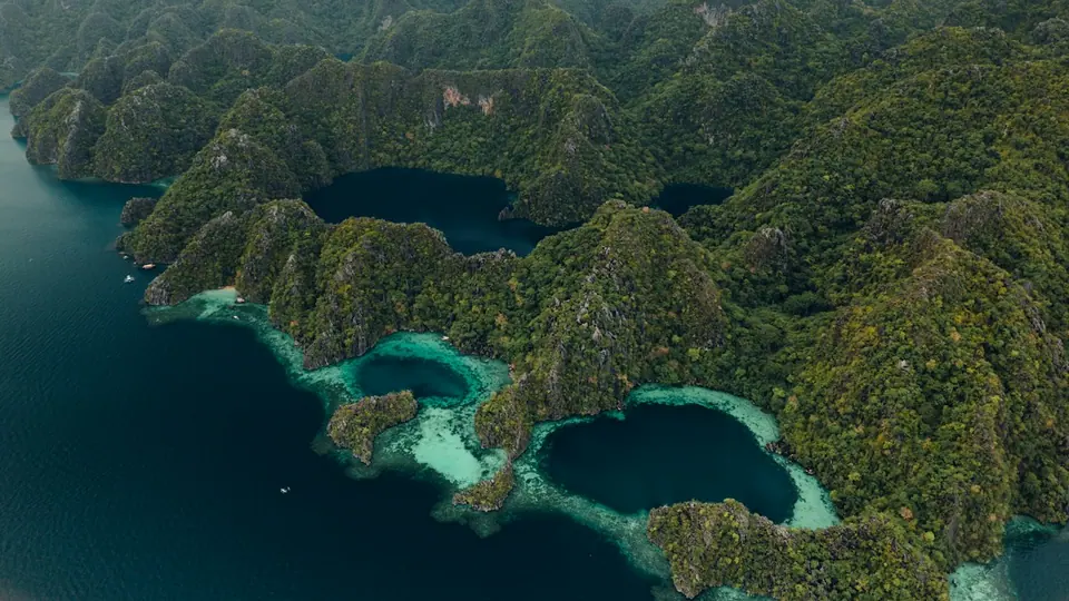 Aerial view of green limestone islands and turquoise lagoons in Palawan